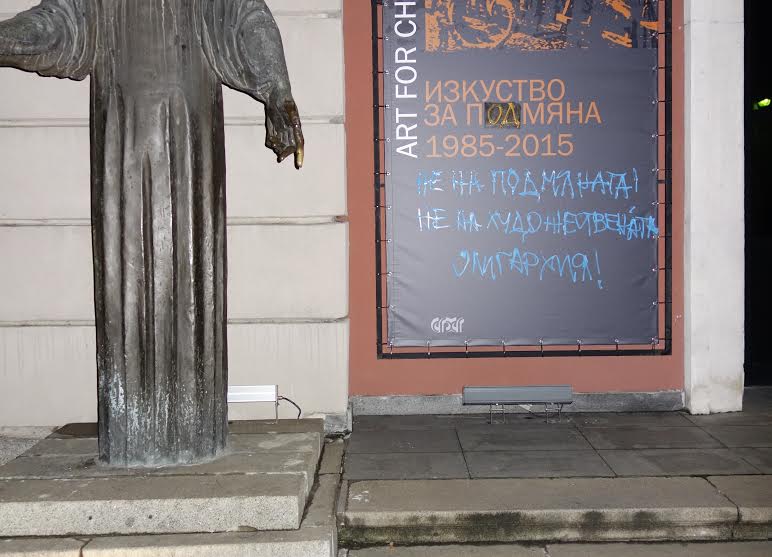 Билбордът на входа на галерията с дописаното заглавие на изложбата.  - Среднощна акция с надписи срещу Софийска градска галерия
